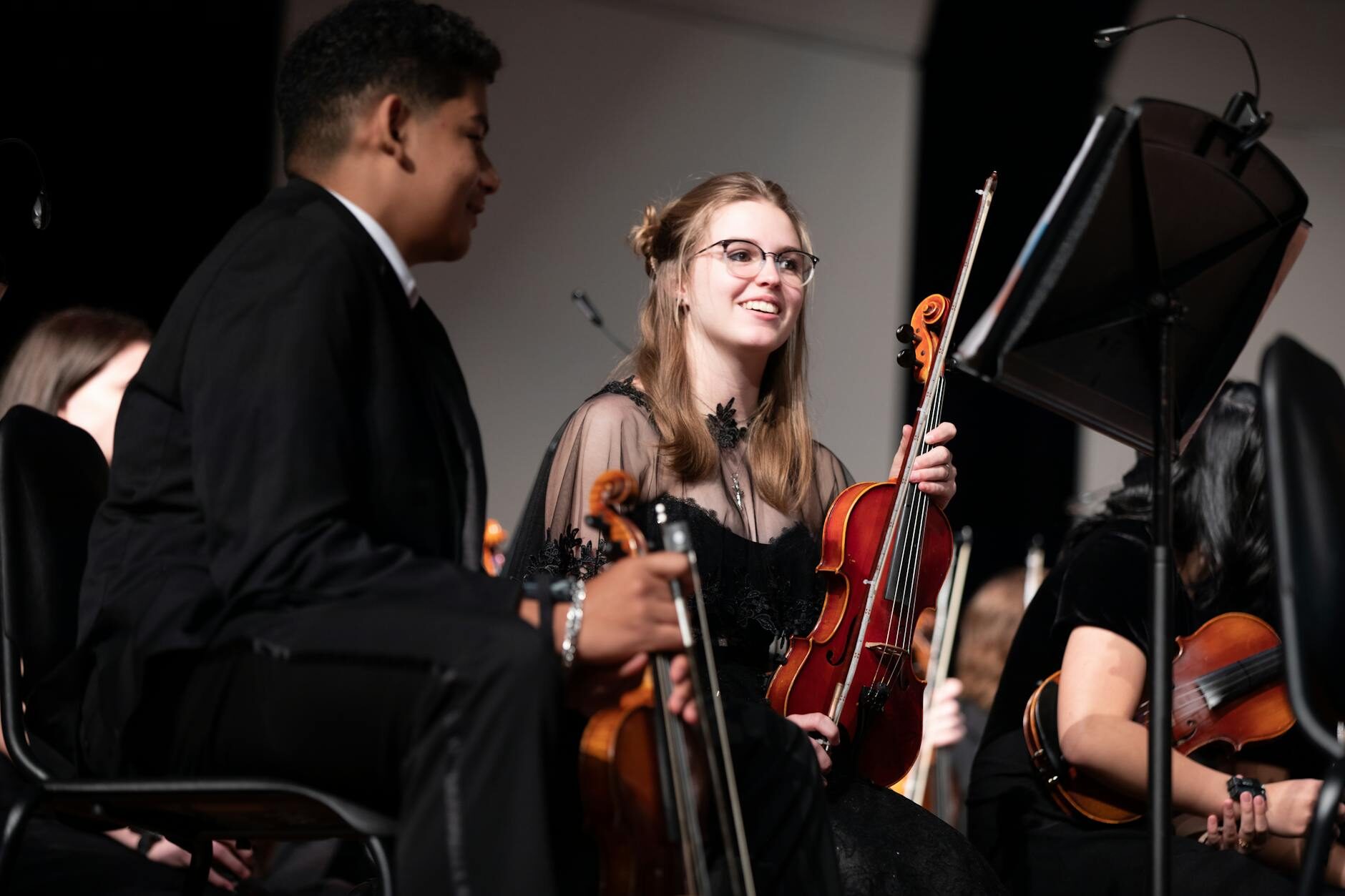 Two young musicians smiling at each other during a rehearsal
