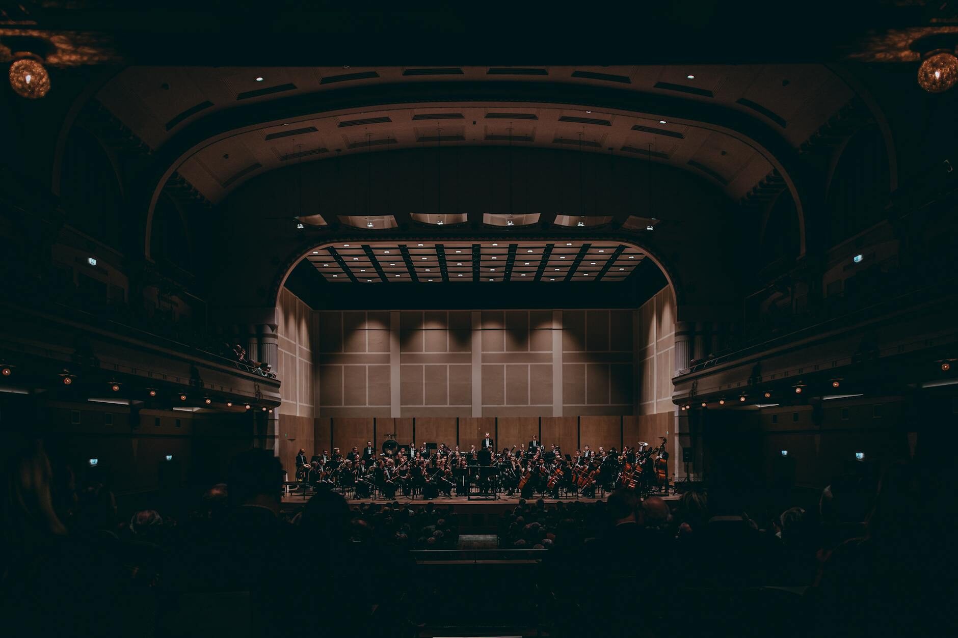 Full symphony orchestra performing on a grand concert hall stage